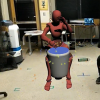 Torin Hopkins beats on a drum next to an avatar also beating on a drum