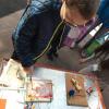 Celeste Moreno shows a young visitor how to make music by painting on a piece of paper during the 2018 Computer Science Education Week.