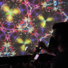 E.O. Rafelson in silouette in front of a large projection of KALEIDEO, a projection from the kaleideoscope he made