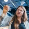 Fiona Bell peels a bioplastic sample off of glass