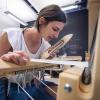 Laura Devendorf weaving on a loom.