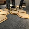 Legs of people standing on the musical hexagons.