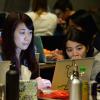 Three students looking at a computer screen while working together at T9Hacks