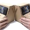 Two hands playing on tinycade cardboard consoles