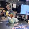 Ruhan Yang sits behind a table showing off paper circuits research at the conference