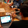Members of CU Science Discovery Robotics Engineering Academy sit around a table.