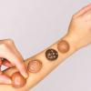A handmade collection of four modular soft wearable sensors with a temperature-dependent dynamic display on a person's arm.