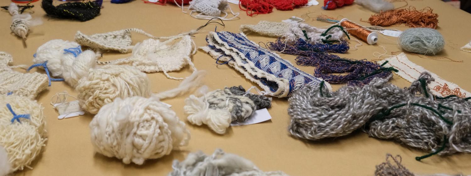 A table with a variety of different yarns varying in texture and size spread out.
