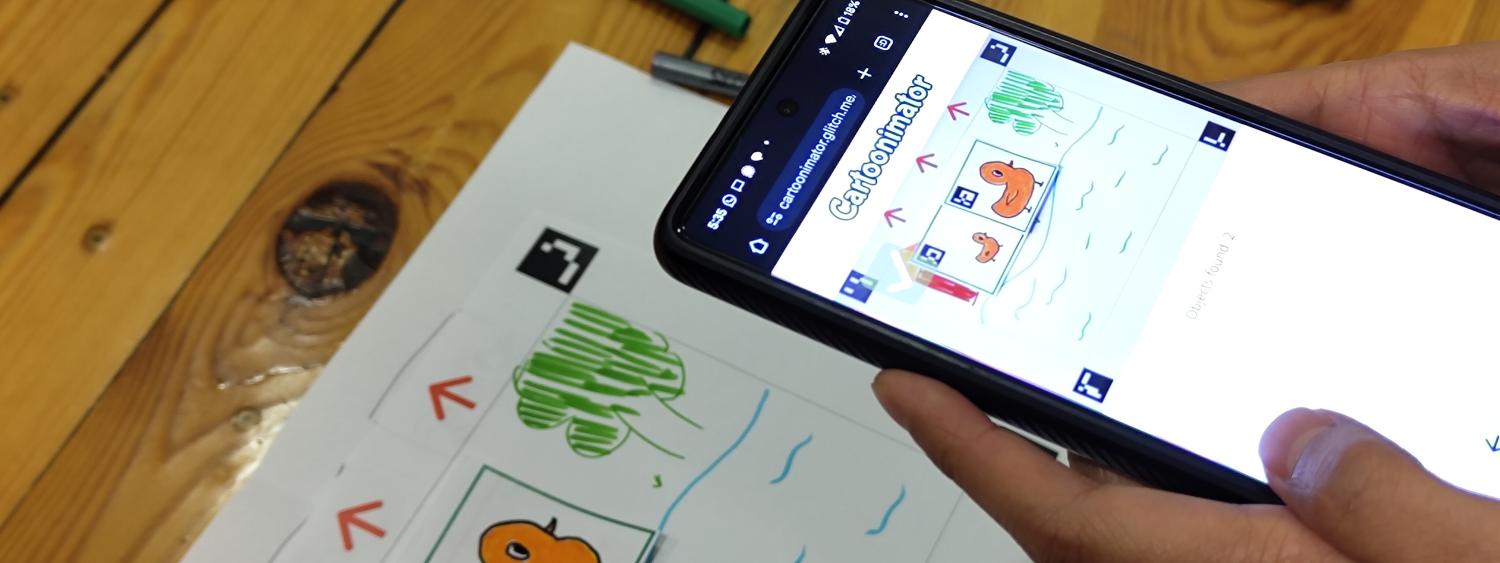 Person holding phone up to a cartoon drawing of ducks on paper