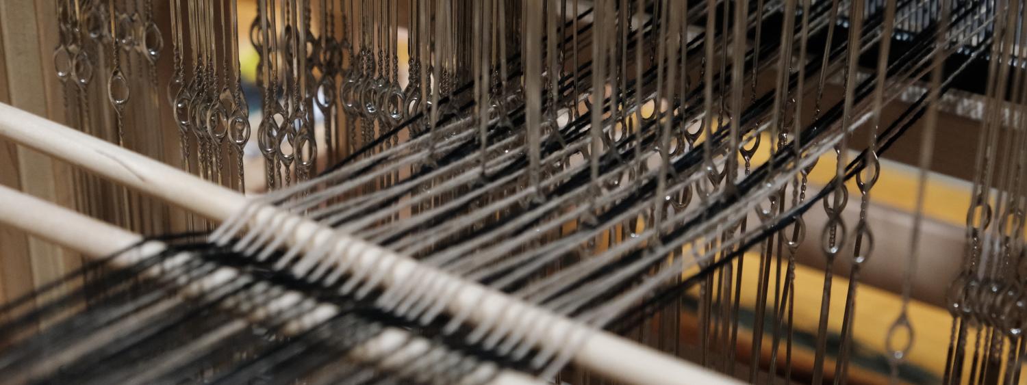 Close up of a loom with threads on it
