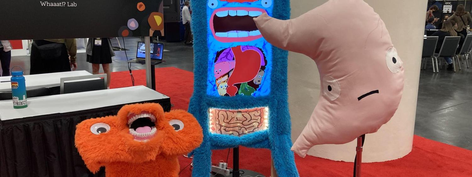 a furry screen, giant stuffed stomach, and an orange furry podium with teeth