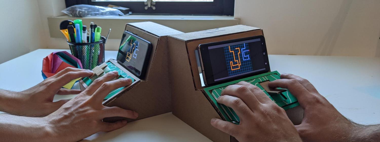 hands playing with tiny arcade screens