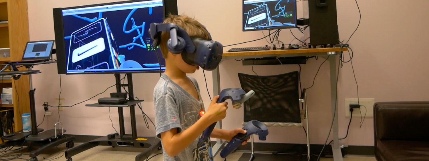 Photo of young boy using VR headset to draw