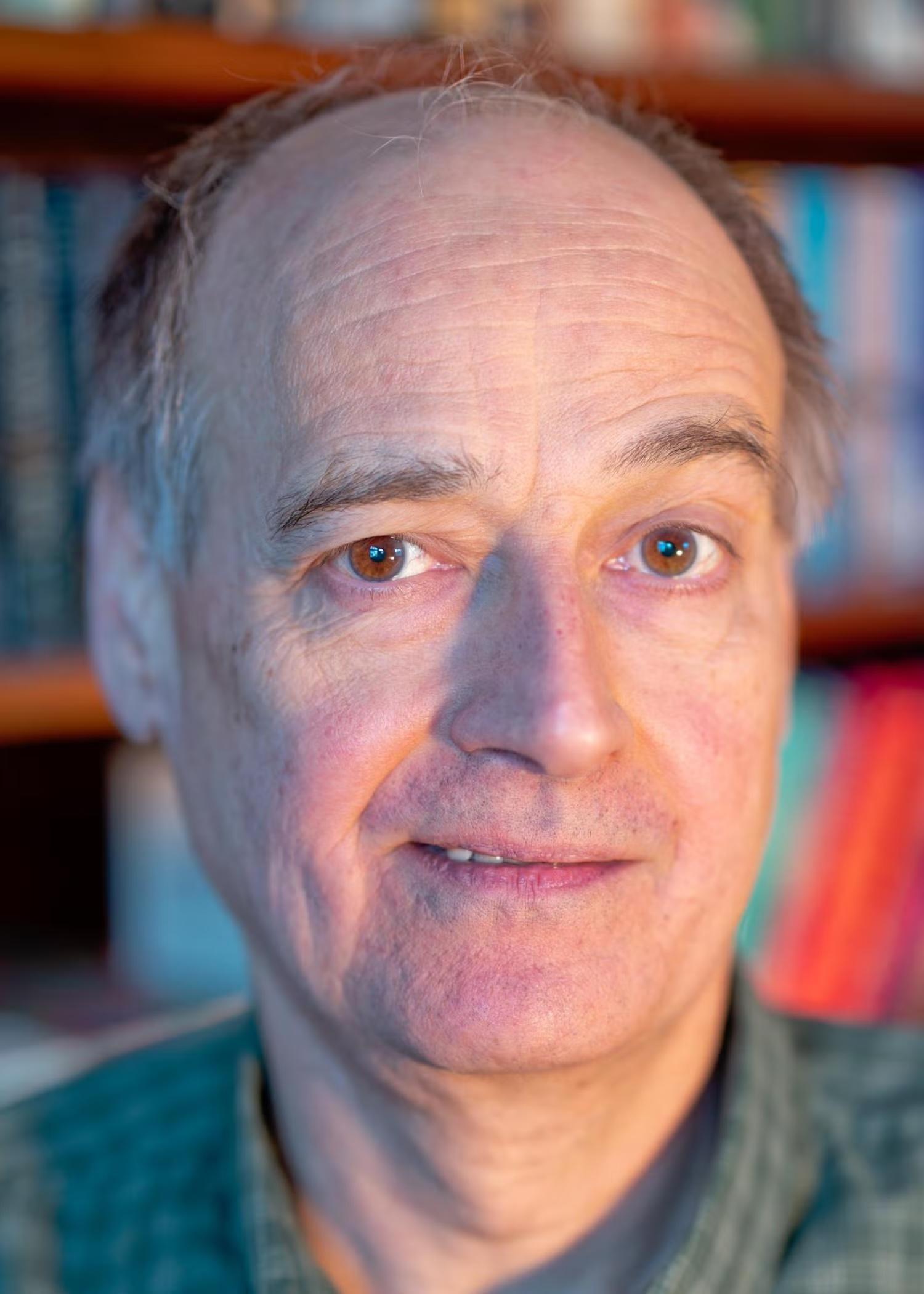 Photo of a middle-aged white man with brown eyes smiling towards the camera