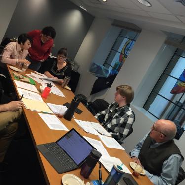 Photo of faculty sitting at a table discussing the honor code