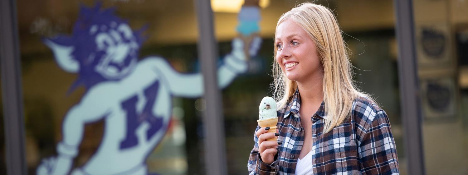 A student holds an ice cream cone in front of Call Hall