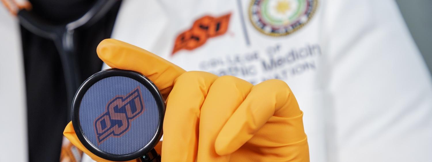 An OSU student holds a stethoscope