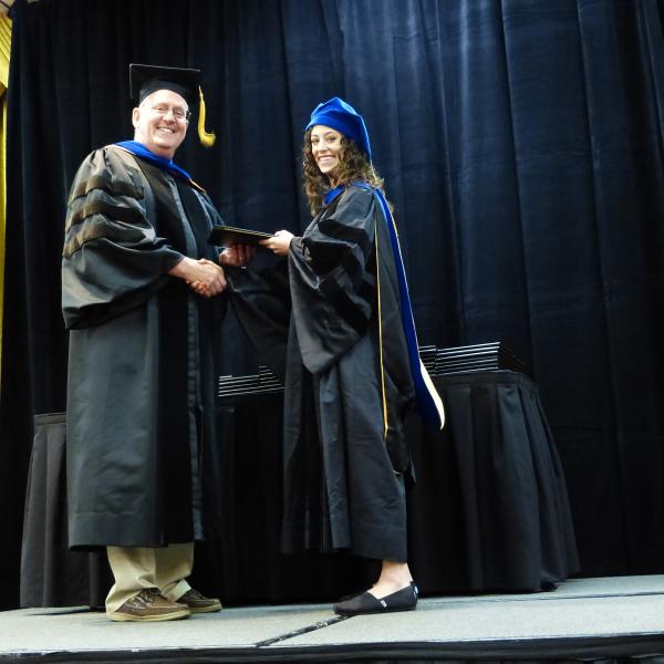 Chair, Carl Koval congratulating Ph.D. graduate Allison Harris