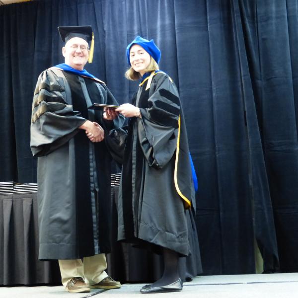 Chair, Carl Koval congratulating Ph.D. graduate Abigail Koss