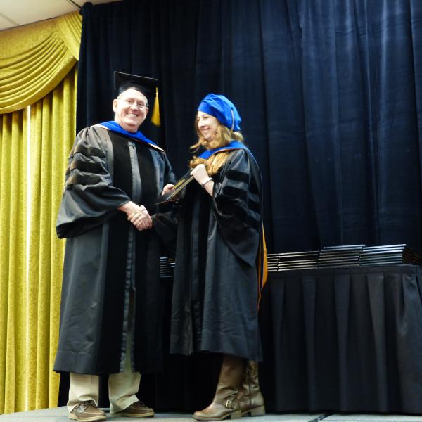 Chair, Carl Koval congratulating Ph.D. graduate Christina Smith