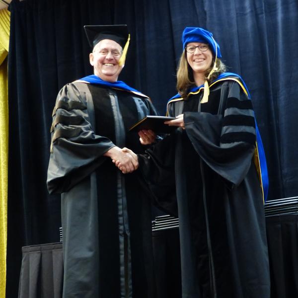 Chair, Carl Koval congratulating Ph.D. graduate Amelia Zutz