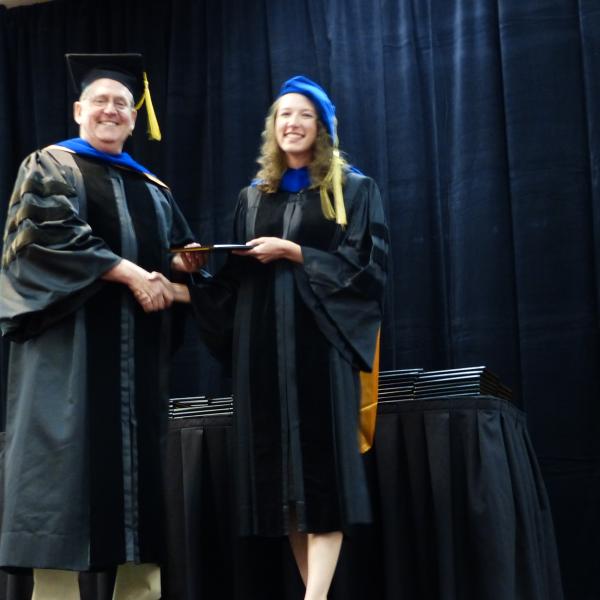 Chair, Carl Koval congratulating Ph.D. graduate Ashley Marshall