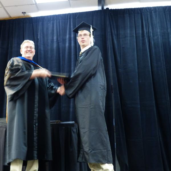Chair, Carl Koval, congratulating undergraduate student_14