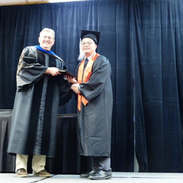 Chair, Carl Koval, congratulating undergraduate student_15