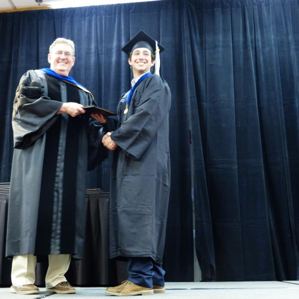 Chair, Carl Koval, congratulating undergraduate student_17