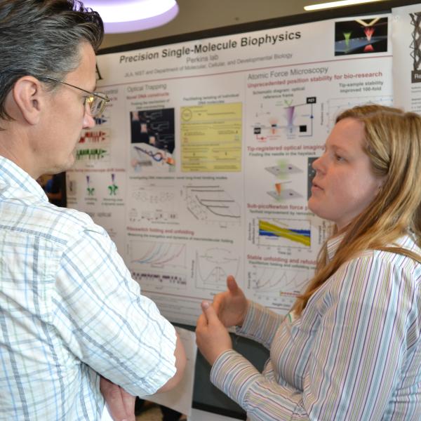 Two scientists discussing a research poster