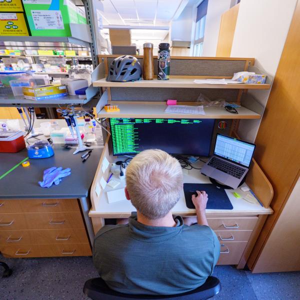 A researcher looking at code on a computer screen
