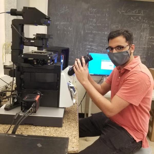A scientist sitting at a microscope