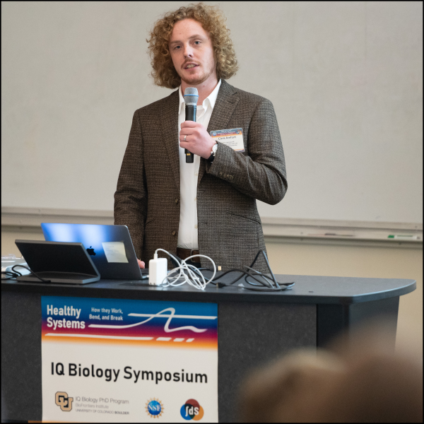 A man holding a microphone talking at a podium