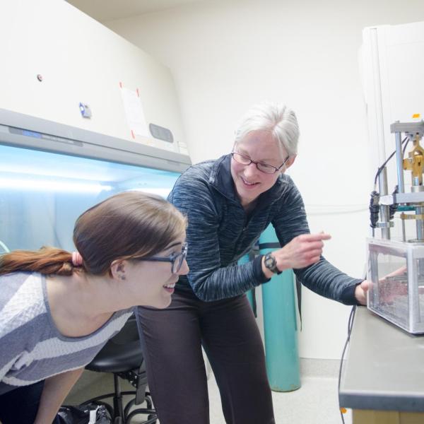 Researchers looking at a piece of scientific equipment