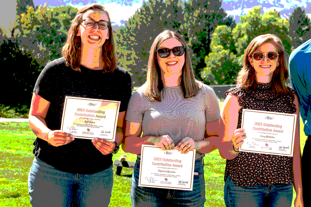 Three people holding certificates