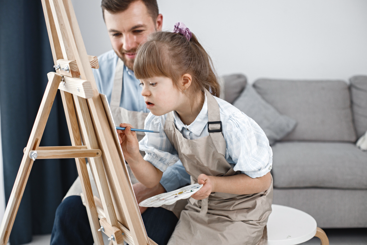 Girl with Down syndrome painting with her dad