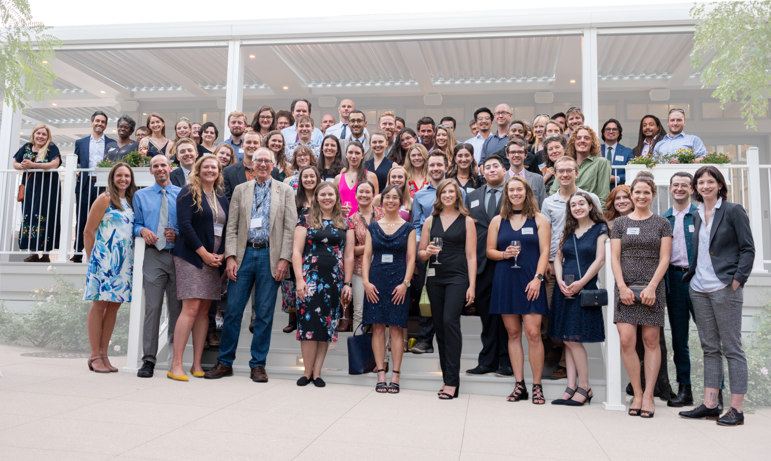 A group of people standing for a portrait, including IQ Bio students, student alumni, program staff, participating faculty, and Board members.