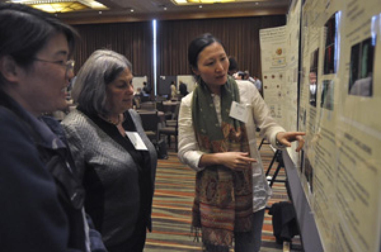 Jane Butcher (center) examines some of CU’s latest research results during the poster session at the 2011 Butcher Symposium. Photo credit: Casey Cass, University of Colorado Boulder