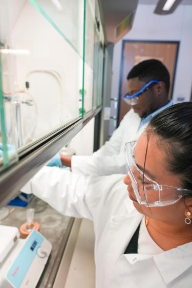 Burdick Lab members in front of a fume hood