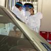 Masked testing site employee shows instructions to a driver at the new testing facility in Denver.