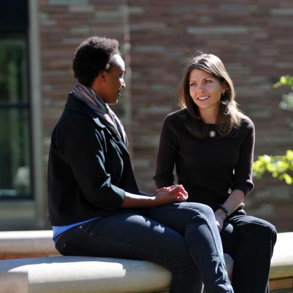 Two people talking on a bench