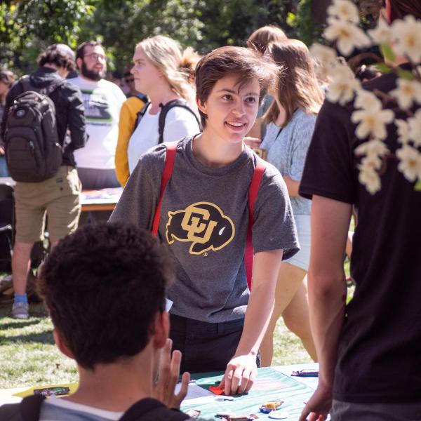 Student standing at table at Be Involved Fair
