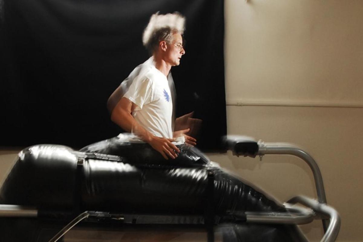 A man with white hair runs on a research machine