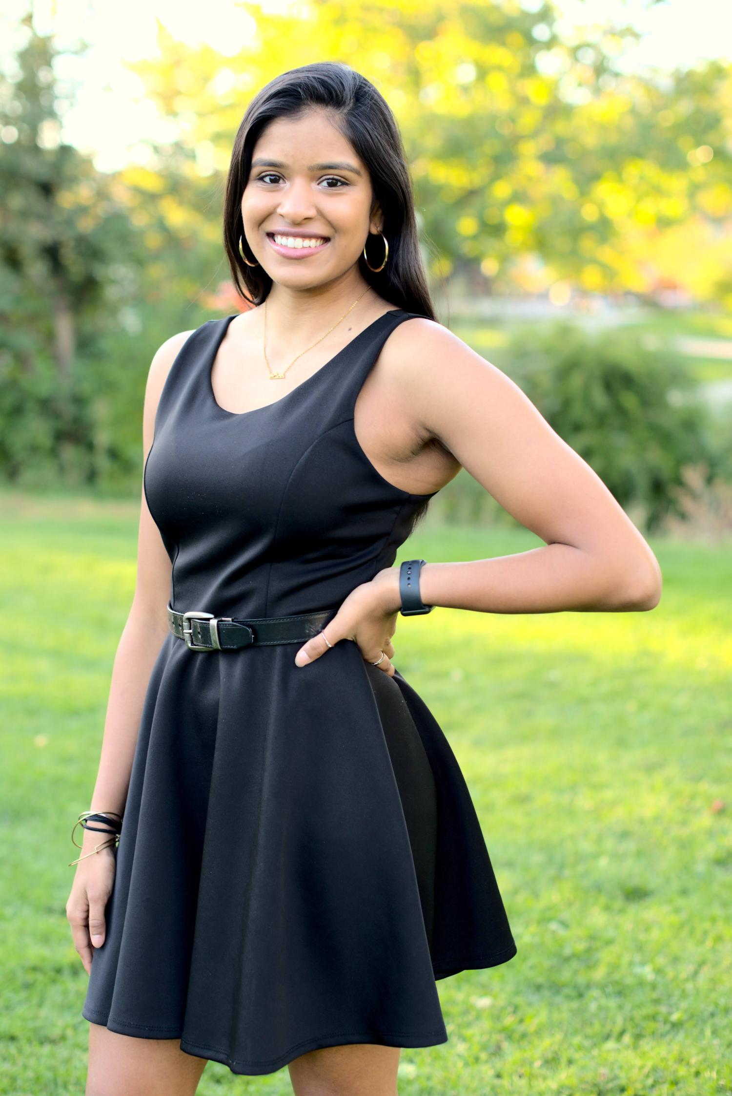 Radhika Headshot in front of green nature background