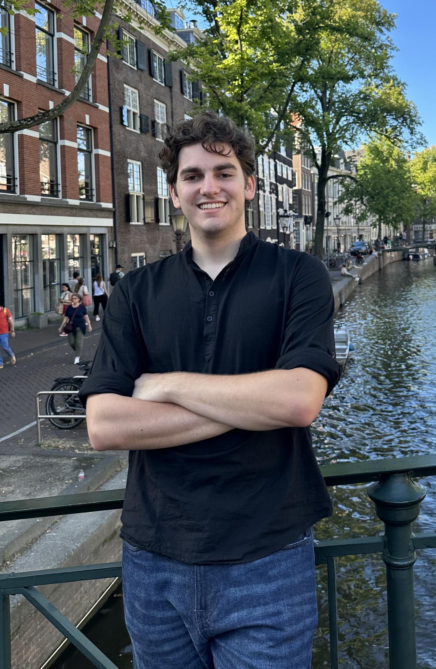 Student Phineas standing in front of a river in urban area