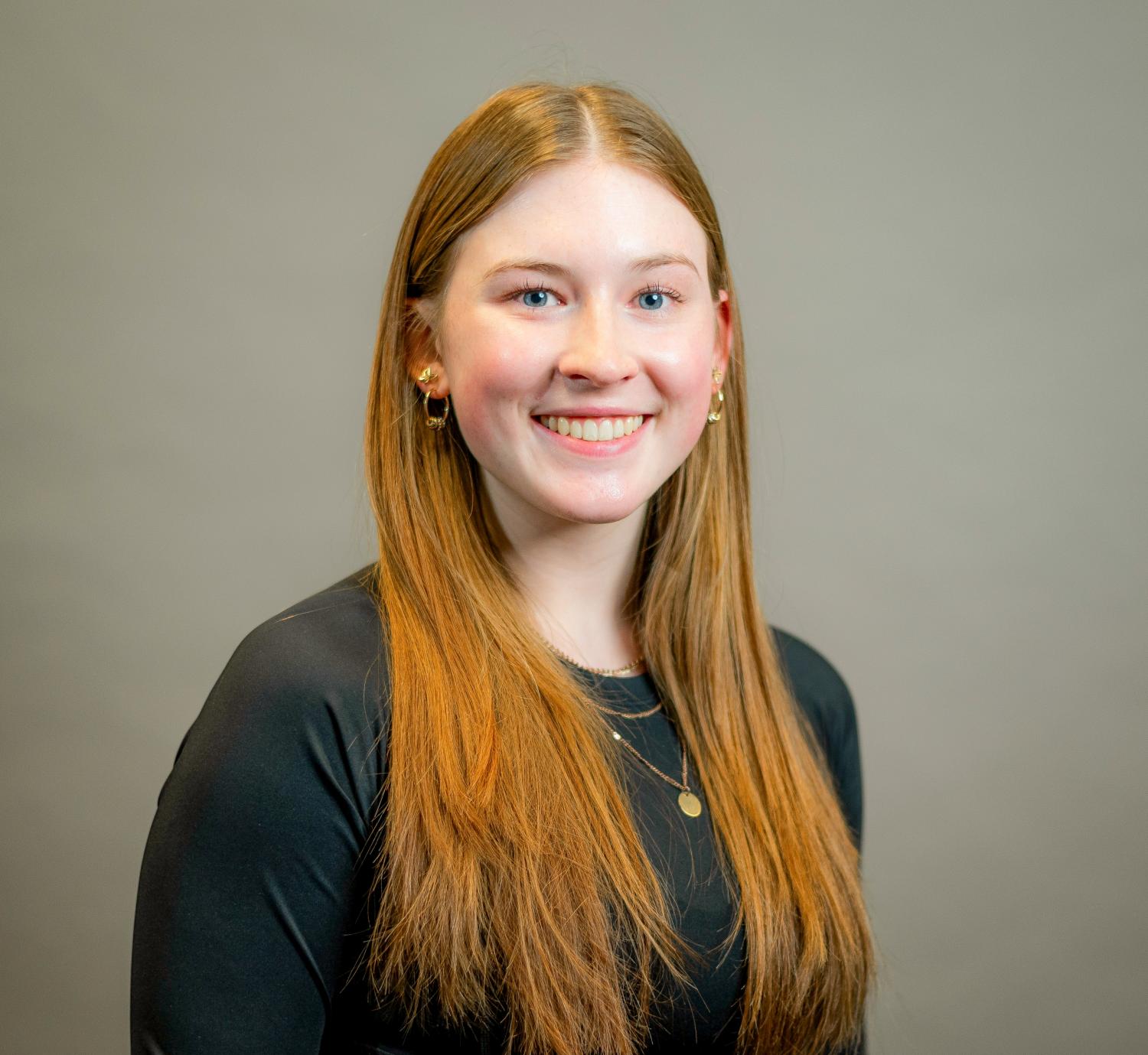 Student with red hair on gray background