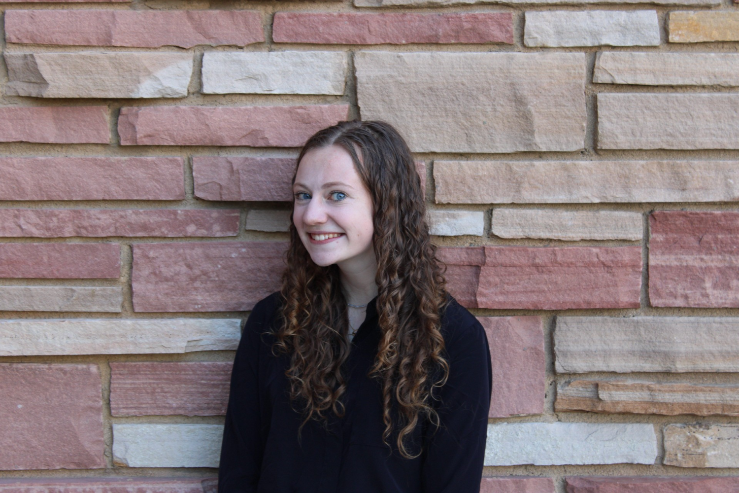 Student in front of brick wall