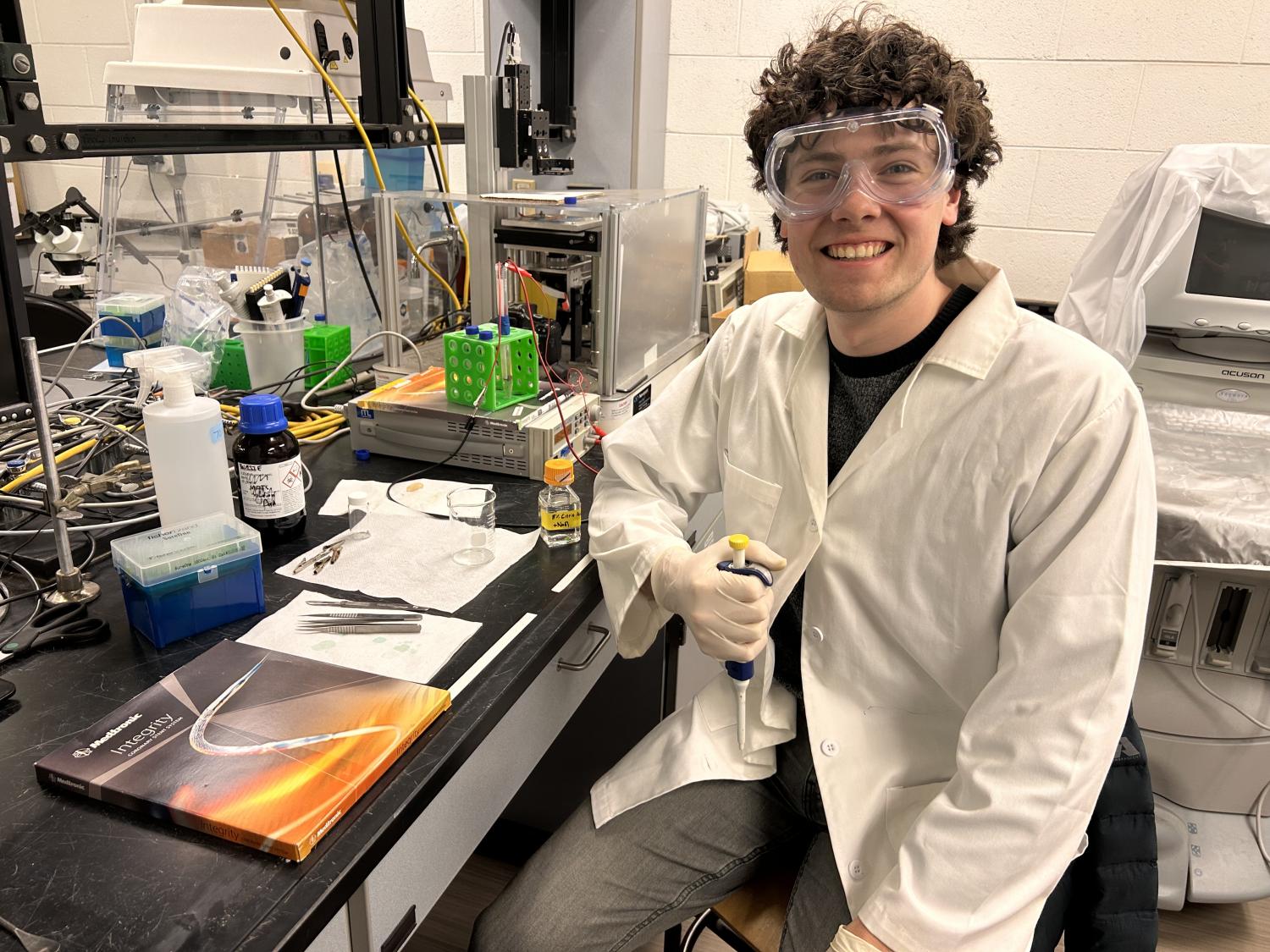 Student sitting near benchtop labratory equiptment