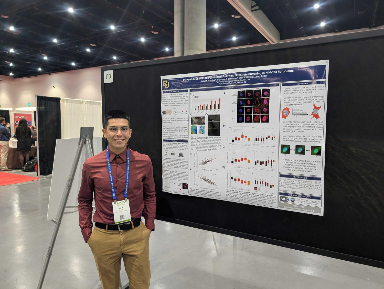 Izaiah Ramirez standing next to his poster at the BMES annual session