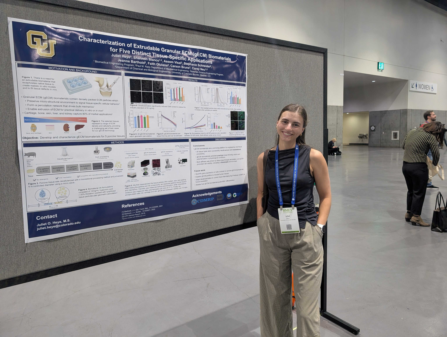 Juliet Heye standing in front of her poster during a BMES session